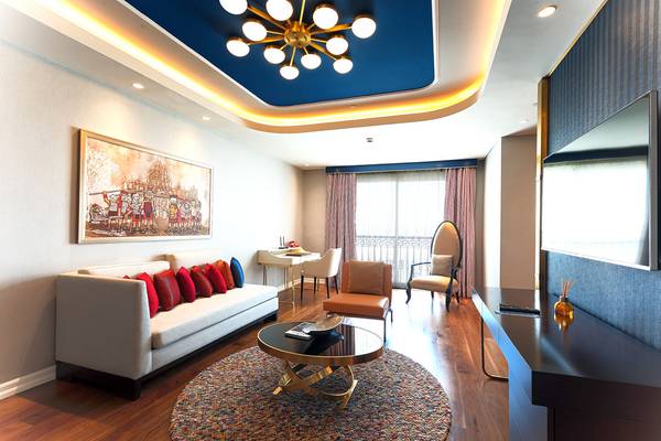 Wohnzimmer im Land of Legends Kingdom Hotel mit einem Sofa, einem Tisch und einem Fernseher.
