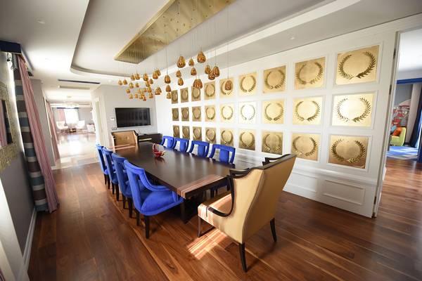 Das Speisezimmer im Land der Legenden Reich mit blauen Stühlen und goldenen Wandpaneelen.