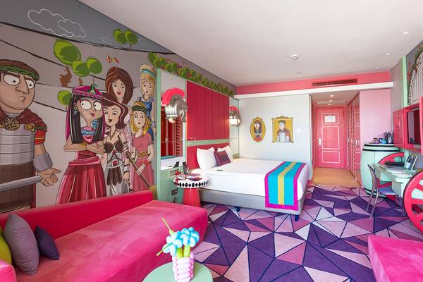 Innenansicht eines Zimmers im Land of Legends Kingdom Hotel mit farbenfrohen Wänden und Möbeln.