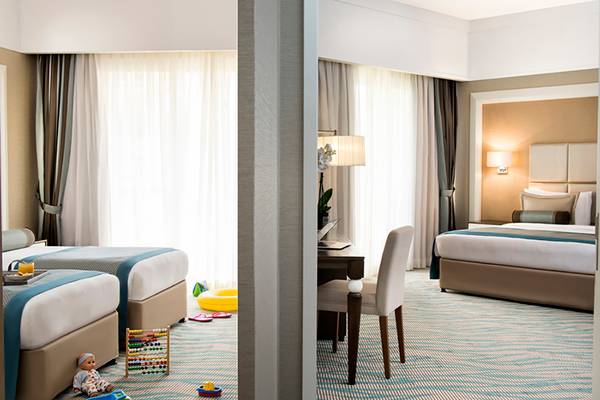 Familienzimmer im Rixos Bab Al Bahr Hotel mit zwei Betten und Spielzeug auf dem Boden.