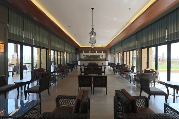 Rixos Bab Al Bahr Hotel Lounge mit Möbeln, Tischen und großen Fenstern.