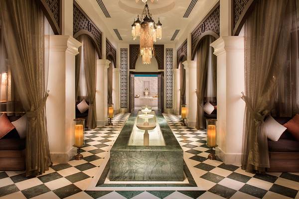 Innenbereich des Rixos Bab Al Bahr Hotels mit gemustertem Boden und Wasserbrunnen.