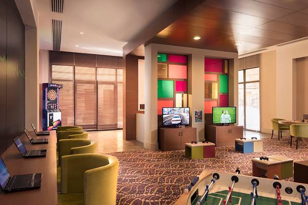 Hotellobby-Spielbereich mit Arcade-Automaten und Fußballtisch im Rixos Bab Al Bahr.