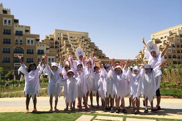Gruppe von Kindern in weißen Kostümen vor dem Hotel Rixos Bab Al Bahr.