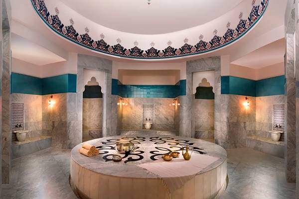 Innenansicht des Hammam im Rixos Bab Al Bahr Hotel mit Marmorwänden und zentralem Tisch.