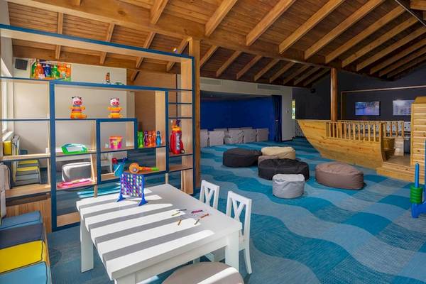 Kinderspielzimmer im Grand Sirenis Punta Cana Resort mit bunten Teppichen und Spielzeug.