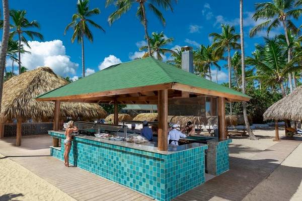 Strandbar im Grand Sirenis Punta Cana Resort mit grünem Dach und blauen Kacheln.