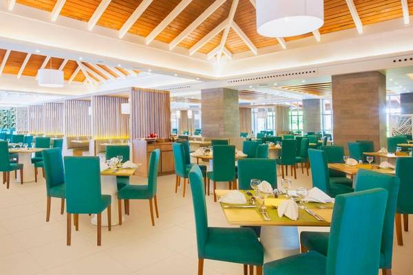 Restaurant im Grand Sirenis Punta Cana Resort mit grünen Stühlen und Tischen.