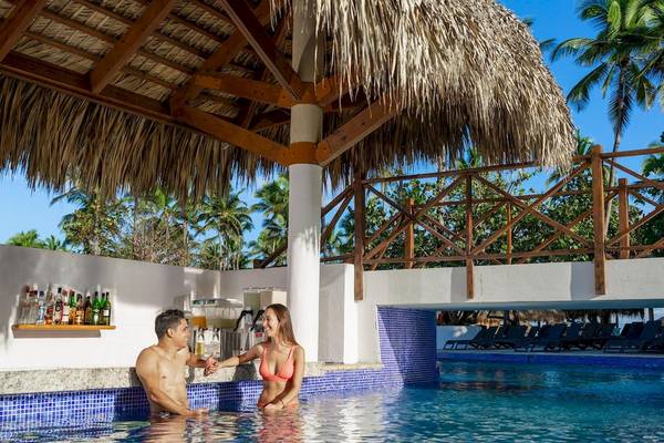 Paar genießt Getränke an der Poolbar im Grand Sirenis Punta Cana Resort