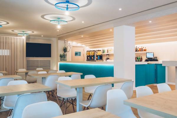 Innenbereich des Iberostar Waves Alcudia Park Hotels mit modernen Möbeln und einem Barbereich.