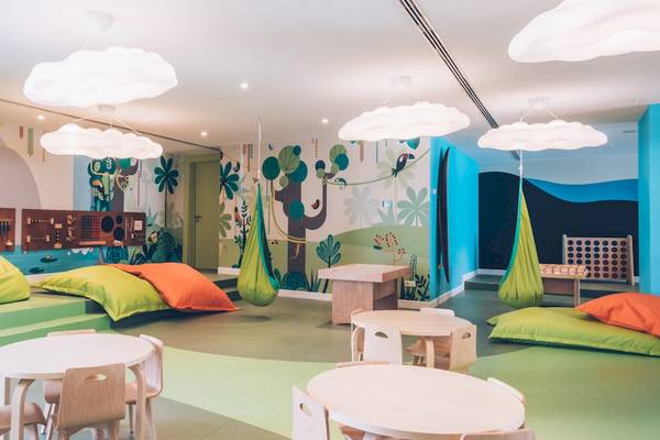 Kinderzimmer im Iberostar Waves Alcudia Park Hotel mit farbenfrohen Wänden, bunten Hängematten und gemütlichen Sitzecken.