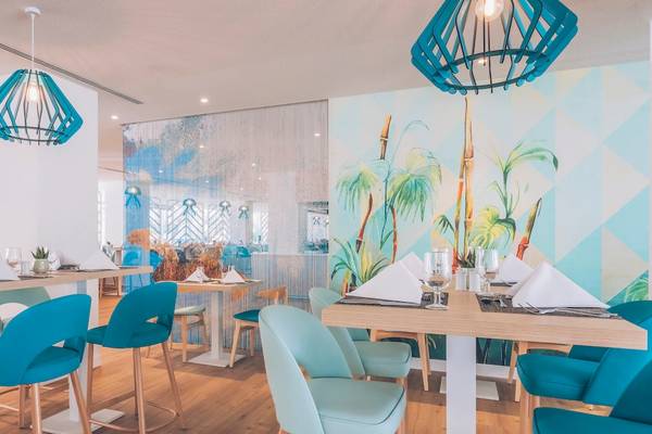 Restaurant-Innenbereich im Iberostar Waves Alcudia Park mit blauen Stühlen und Tischen.