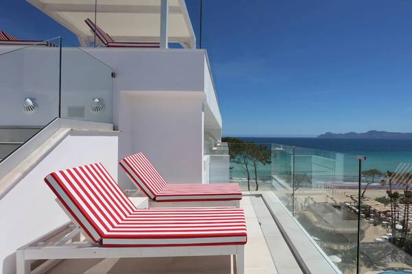 Terrasse des Iberostar Waves Alcudia Park mit Blick auf den Strand und das Meer.