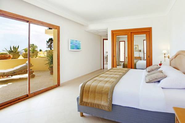 Schlafzimmer im Mövenpick Resort & Marine Spa Sousse mit Doppelbett, großer Glastür und Balkon