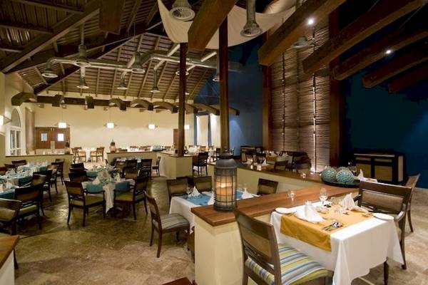 Innenansicht des Restaurants im Dreams Royal Beach Punta Cana Hotel mit gedeckten Tischen und Stühlen.