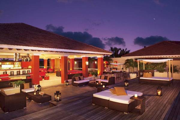 Abendliche Lounge im Dreams Royal Beach Punta Cana mit beleuchteten Möbeln und Pflanzen.