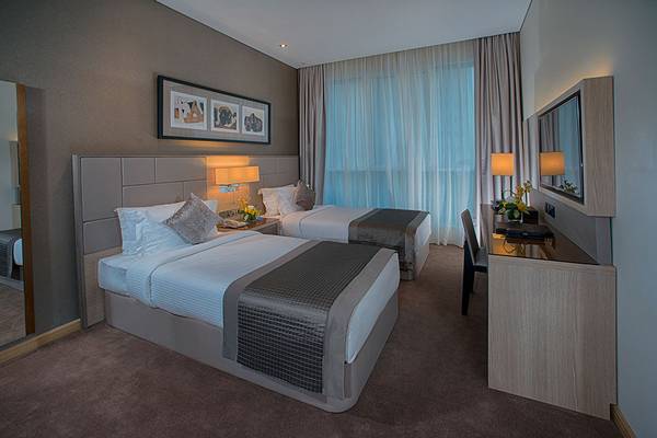Doppelzimmer im TRYP by Wyndham Abu Dhabi City Center Hotel mit zwei Betten, Dekor und Möbeln.
