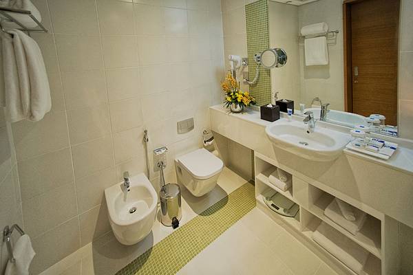 Badezimmer im TRYP by Wyndham Abu Dhabi City Center mit Toilette, Bidet, Waschbecken und Spiegel.