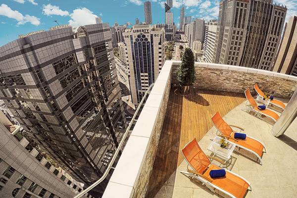 Oberne Aussicht des TRYP by Wyndham Abu Dhabi City Centers mit mehreren orange Liegestühlen auf dem Balkon.