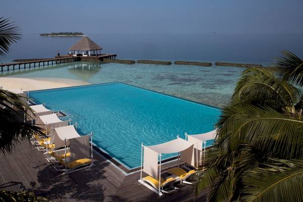 Ein riesiger Pool mit Liegen und Sonnenschirmen am Coco Bodu Hithi Hotel.