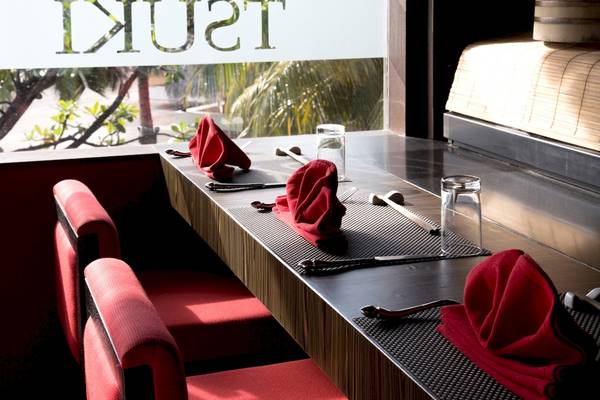 Tischdekoration im Coco Bodu Hithi Hotel mit roten Servietten und Besteck.