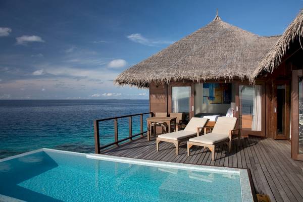 Pool-Terrasse des Coco Bodu Hithi Hotels mit Blick auf das Meer.