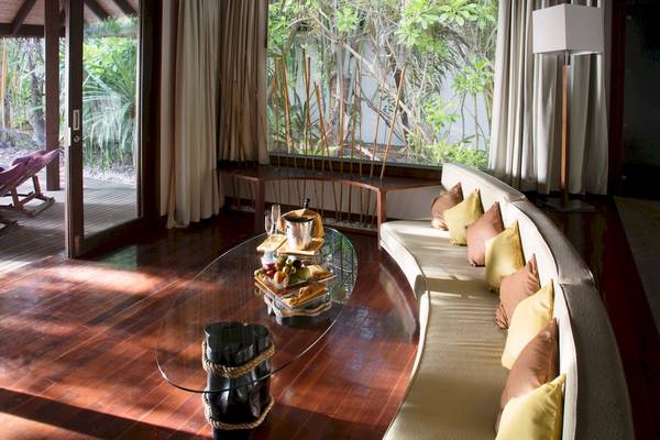 Inneneinrichtung des Coco Bodu Hithi Hotels mit offenem Fenster und Glastisch.