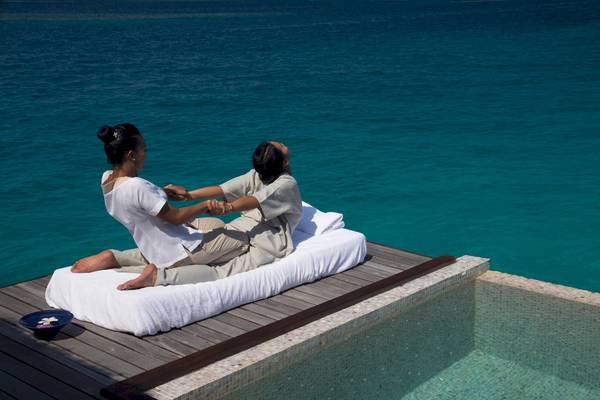 Massagebehandlung am Pool im Coco Bodu Hithi Hotel