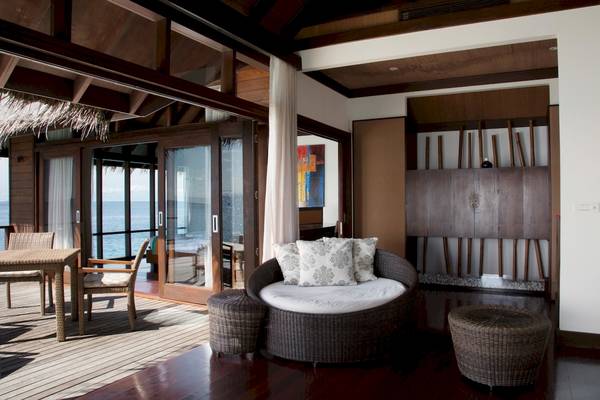 Innenbereich des Coco Bodu Hithi Hotels mit Terrassenmöbeln und Meerblick
