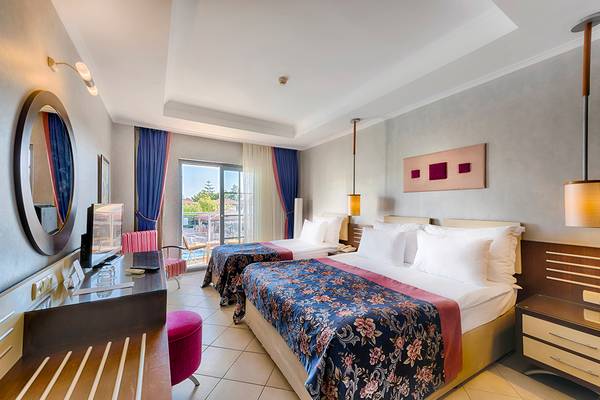 Doppelzimmer im Club Nena Hotel mit zwei Betten, Fernseher, und einem Balkon.