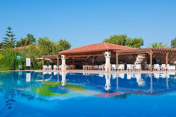 Außenpool des Club Nena Hotels mit umliegenden Bäumen und Sitzbereich.