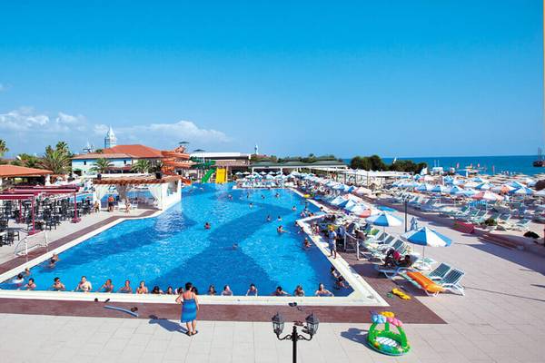 Aussicht auf den Swimmingpool des Club Nena Hotels mit vielen Gästen und Sonnenschirmen.