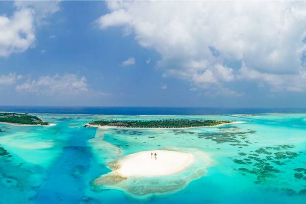 Luftaufnahme des Innahura Maldives Resorts, das auf einer kleinen Insel im Ozean liegt.