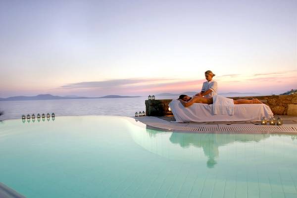 Massage am Pool des Mykonos Grand Hotel & Resort bei Sonnenuntergang