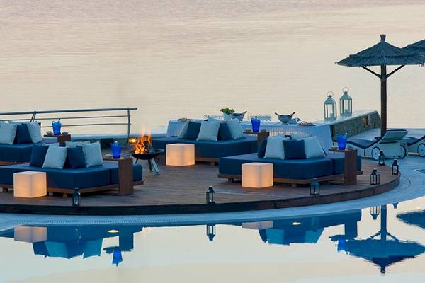 Pool-Lounge-Bereich im Mykonos Grand Hotel & Resort mit Blick auf das Meer.