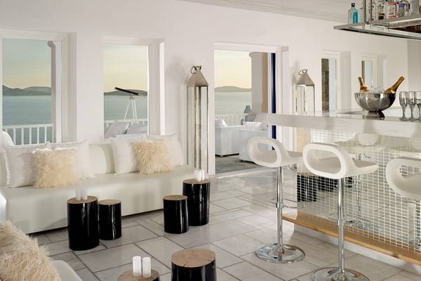 Innenansicht des Barbereichs im Mykonos Grand Hotel & Resort mit Blick auf das Meer.