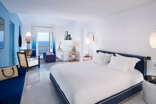 Schlafzimmer im Mykonos Grand Hotel & Resort mit Blick auf das Meer.
