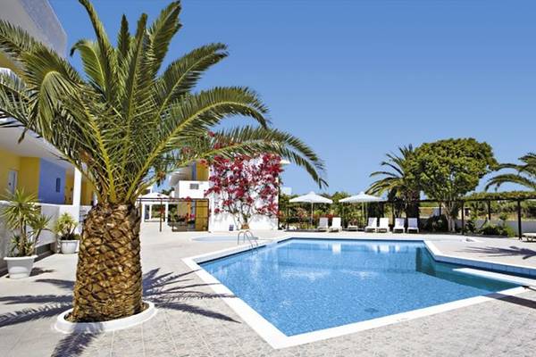 Außenbereich des Golden Star Hotels in Kos mit Swimmingpool, Palmen und Sonnenliegen.