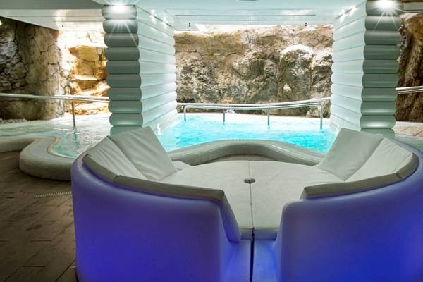 Pool-Lounge-Bereich im Bull Dorado Beach & Spa Hotel mit künstlicher Höhle und blauen Lichtern.