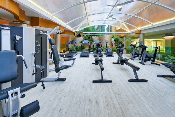 Fitnessstudio im Bull Dorado Beach & Spa mit verschiedenen Trainingsgeräten und einer großen Glasdecke.