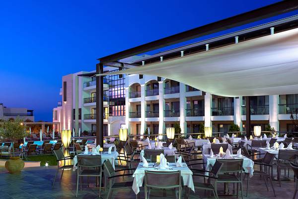 Außenbereich des Albatros Spa & Resort Hotels am Abend mit illuminierten Tischen und Stühlen.