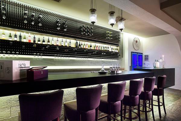 Innenansicht der Bar im Albatros Spa & Resort mit vielen Weinflaschen und Barhockern.