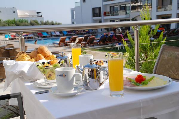 Frühstück auf dem Balkon im Albatros Spa & Resort mit Blick auf den Pool und Sonnenliegen.