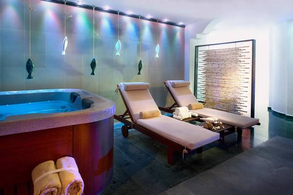Jacuzzi-Bereich im Albatros Spa & Resort mit zwei Liegen und beleuchteten Fischdekorationen.