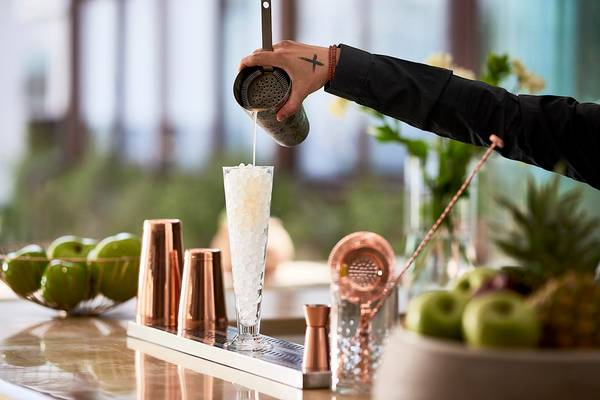 Eine Person schüttet einen Cocktail in ein Glas mit Eis im Albatros Spa & Resort.