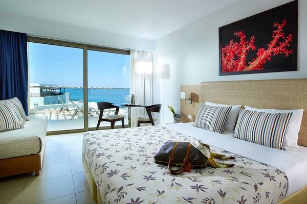 Hotelzimmer im Albatros Spa & Resort mit Meerblick, Doppelbett, Balkon und Sonnenstuhl.
