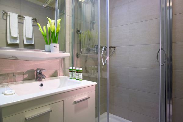 Badezimmer des Albatros Spa & Resort mit Dusche, Waschbecken und Pflegeprodukten.