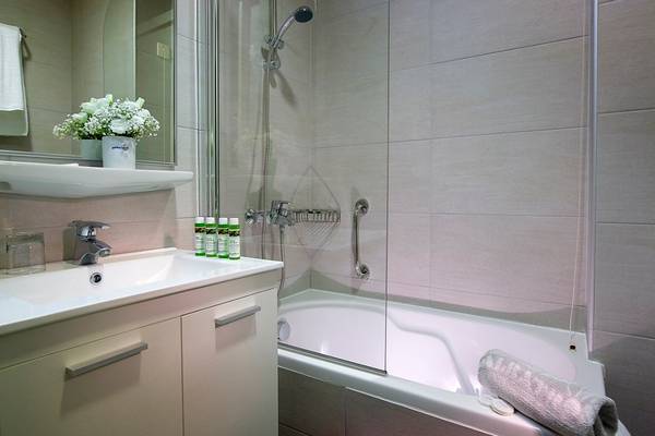 Badezimmer im Albatros Spa & Resort mit Badewanne, Dusche, Handtüchern und Toilettenartikeln