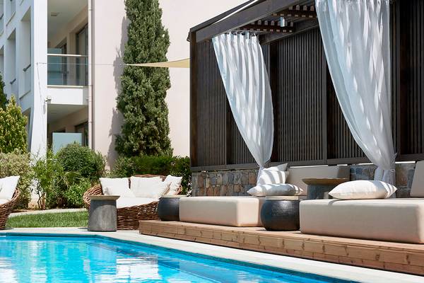 Pool-Loungebereich im Albatros Spa & Resort mit weißen Vorhängen und Möbeln.