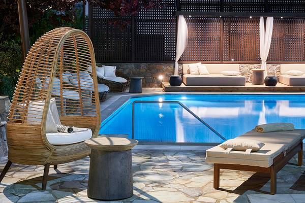 Außenbereich des Albatros Spa & Resort mit einem Pool, Liegestühlen und Kissen.